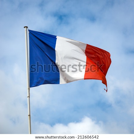 French flag against blue cloudy sky.
