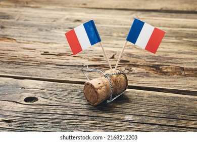French flags on a french champagne bottle cork on an old wooden table, Bastille Day and French National Day 14 July concept