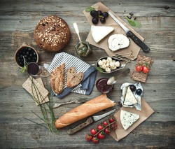 Französisches Essen Auf Holzhintergrund. Verschiedene Arten Von Käse, Wein Und Anderen Zutaten Auf Einem Holztisch