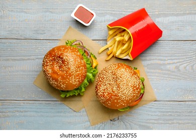 French Fries, Burgers And Ketchup On Grey Wooden Table, Flat Lay. Fast Food