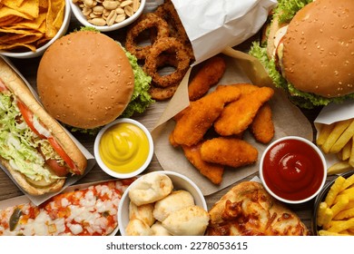 French fries, burgers and other fast food as background, top view - Powered by Shutterstock