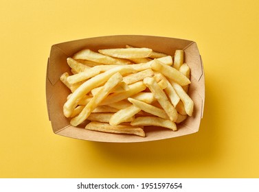 French Fries In Cardboard Container On Yellow Background, Top View