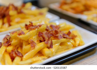 French Fries And Cheese With Bacon On Top  In A White Bowl