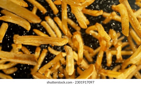 French fries - fried potatoes flying. Fly fastfood isolated on black background. - Shutterstock ID 2301917097