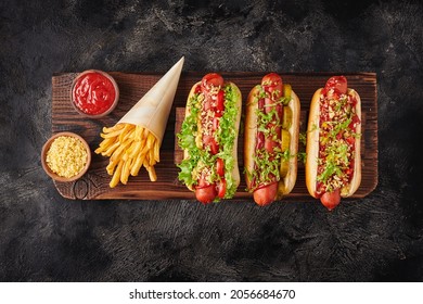 French fries and hot dogs on wooden board