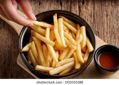 French fries with ketchup on a dark wood background. fastfood snack.