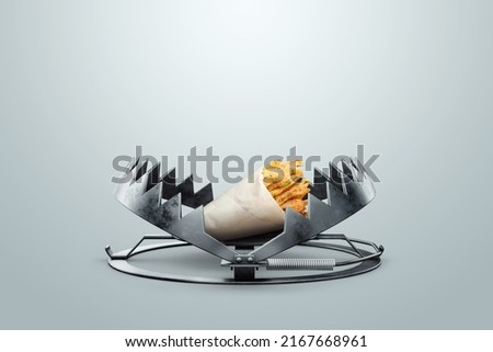 french fries in a large metal bear trap, close-up. The concept of gluttony, obesity, fast food, addiction, malnutrition