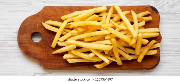 French Fries On Rustic Wooden Board On A White Wooden Background, Top View. From Above, Flat, Overhead.