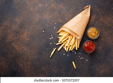 French fries in a paper bag with sauces. Top view - Powered by Shutterstock