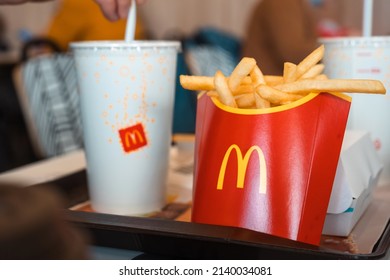 French fries with a red box with the McDonald's logo on a tray and a drink. Fast food restaurant chains. Russia, Kaluga, March 21, 2022.