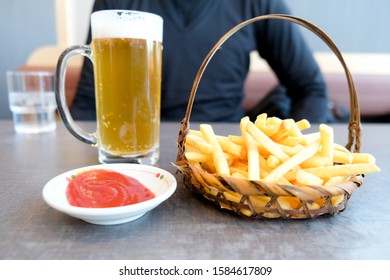 French Fries Served In Basket And Cold Of Beer In Cold Weather