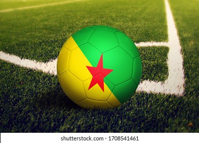 French Guiana flag on ball at corner kick position, soccer field background. National football theme on green grass. - Powered by Shutterstock