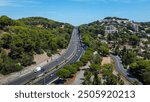 French highway seen from a drone. Road which means travel, road trip, journey in summer. Road that passes along the sea and through houses and populated areas.