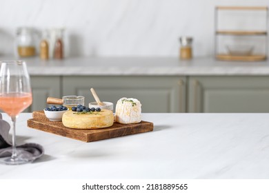 French And Italian Cheeses. Cheese And Wine Concept. Reblochon, Langres On Wooden Cutting Board With Fruits And Honey. Cheese Plate, Dish. Kitchen Background.