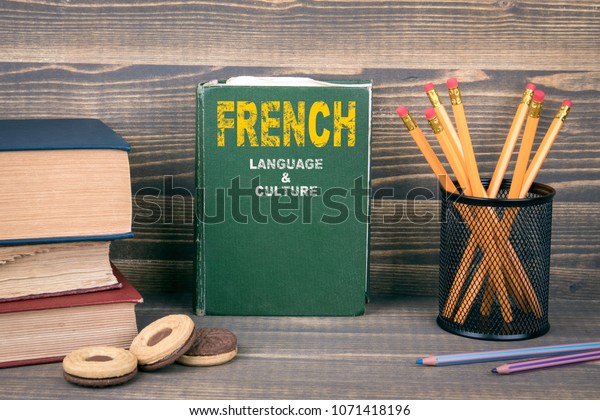 French language and culture concept. Book on a\
wooden background