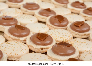 French Macarons Making. Meringue Shells With Salted Caramel Filling With Shards Of Hard Candy.