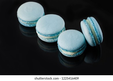 French macarons. Stack of blue macaron with dorblu and wine isolated on dark,  black mirror background. Colorful macaroons. Top view - Shutterstock ID 1225416409