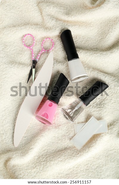 French manicure set with strengthener,white\
tip polish, dividers and top coat shine applicator for nails on\
towel background