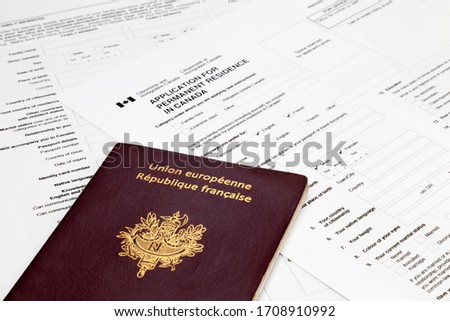 A French passport on the top of an Canadian application form to obtain a Permanent residence visa.