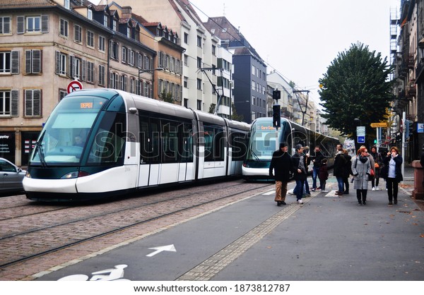French people and travelers foreign walking and\
waiting tramway and bus go to destination at train station with\
traffic road at old town of Strasbourg on November 30, 2019 in\
Grand Est region, France