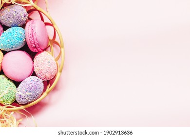 French pink macaroon cookies with Easter decorative eggs.