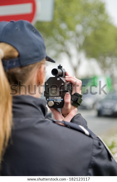 A french police woman control car speed with a\
mobile radar