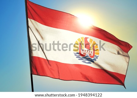 French Polynesia flag waving on the wind in front of sun