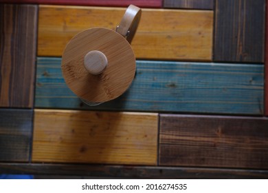 French Press Coffee Maker Made Of Wooden Material And Colorful Wooden Background And Caffe Standing On Wooden Table.