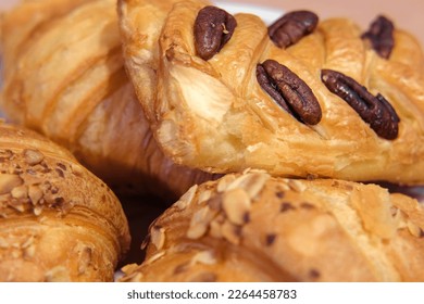 French puff pastry and croissant with toppings. Freshly baked sweet buns couple flaky pastry with almond nuts in a white plate for dessert. Delicious Breakfast or brunch concept. Burekas, turnovers. - Powered by Shutterstock