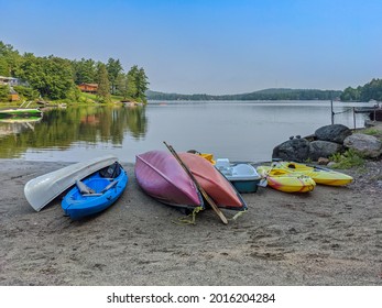 French River, Ontario, Canada - Jul 25, 2021: Many Colorful Kayaks, Canoes, Paddle Boats On A Sandy Beach By The Lake In A Cottage Country. Summer Vacation Concept.