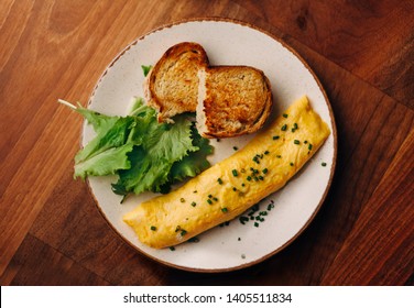 French Rolled Omelette With Chives On A Plate