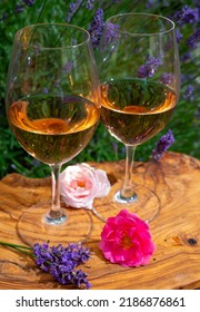 French Rose Wine From Provence, Two Glasses Of Wine With Purple Lavender Flowers On Background Served On Olive Tree Plank Outdoor In Sunny Day