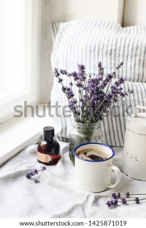 French summer still life. Cup of coffee, lavender flowers bouquet, essence oil bottle on windowsill. Feminine styled stock photo, floral composition with Lavandula officinalis herbs. Rustic scene, ver
