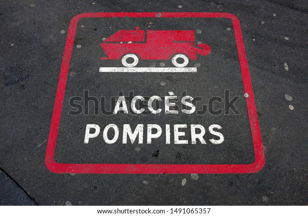 French text: Accès Pompiers.
English translation:
Firefighters Access.
Marking on the road with red fire engine
drawn.