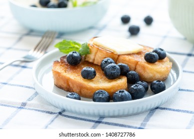 French toast with blueberries, honey and butter on a light plate. Sweet country breakfast. - Powered by Shutterstock