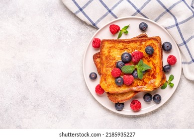 French toast with blueberries, raspberries, maple syrup, top view.