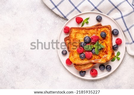 French toast with blueberries, raspberries, maple syrup, top view.