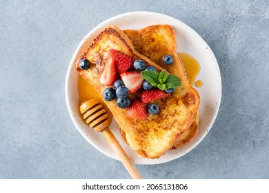 French Toasts With Honey And Fresh Berries On White Plate, Table Top View. Sweet Breakfast Or Dessert Food