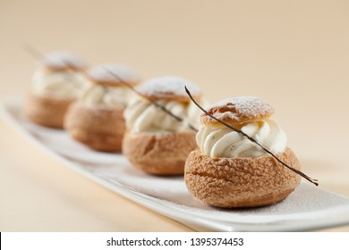 French traditional dessert Choux pastry ball with vanilla cream and vanilla stick