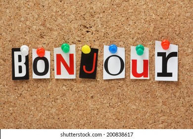 The French word Bonjour in cut out magazine letters pinned to a cork notice board