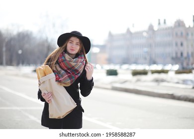 Frenchwoman with baguettes in the bag on the way out of the store
 - Powered by Shutterstock