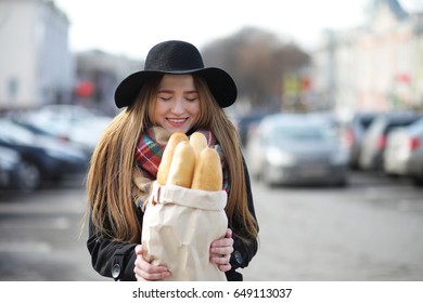 Frenchwoman with baguettes in the bag on the way out of the store
 - Powered by Shutterstock