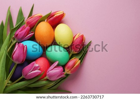 Fresch colorful tulip flowers and easter eggs on pink background. Top view with copy space. Happy easter greeting card.