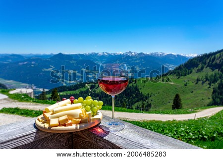 fresch tirol tyrol cheese with wine and grapes over mountain landscape