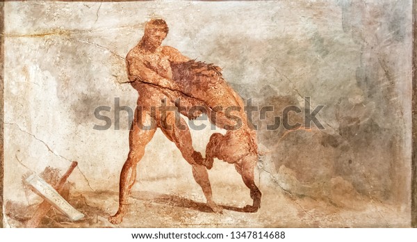 Fresco from Pompeii, Italy. Wall painting with Hercules fighting lion. Greek Roman mythology mural inside Ancient house. Old art frescoes are tourist attractions of Pompeii. Naples - May 13, 2014.