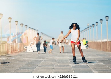 Fresh air and rollerblades is how I start my day. Shot of an attractive young woman rollerblading on a boardwalk.