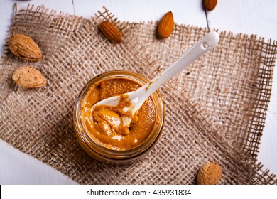 Fresh Almond Butter With Ceramic Spoon In Jar.