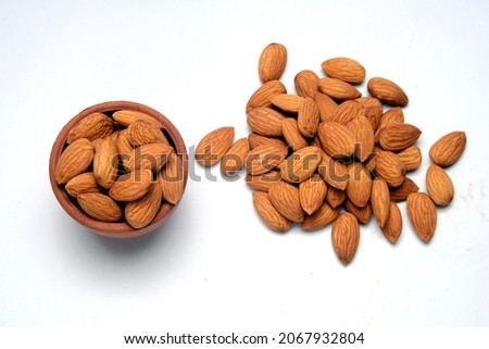Fresh almonds in the wooden bowl, Organic almonds, almonds border white background, Almond nuts on a dark wooden background. Healthy snacks. Top view. Free space for text.
