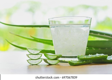 fresh aloe vera leaves and aloe vera juice in glass on wooden background