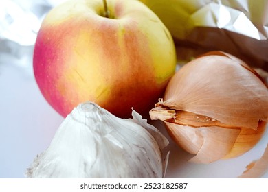 fresh apple, garlic bulbs, onion layers with vibrant colors and natural textures on a light background, showcasing organic produce greens vegan vegetarian dish ingredients in the fridge quick meal - Powered by Shutterstock